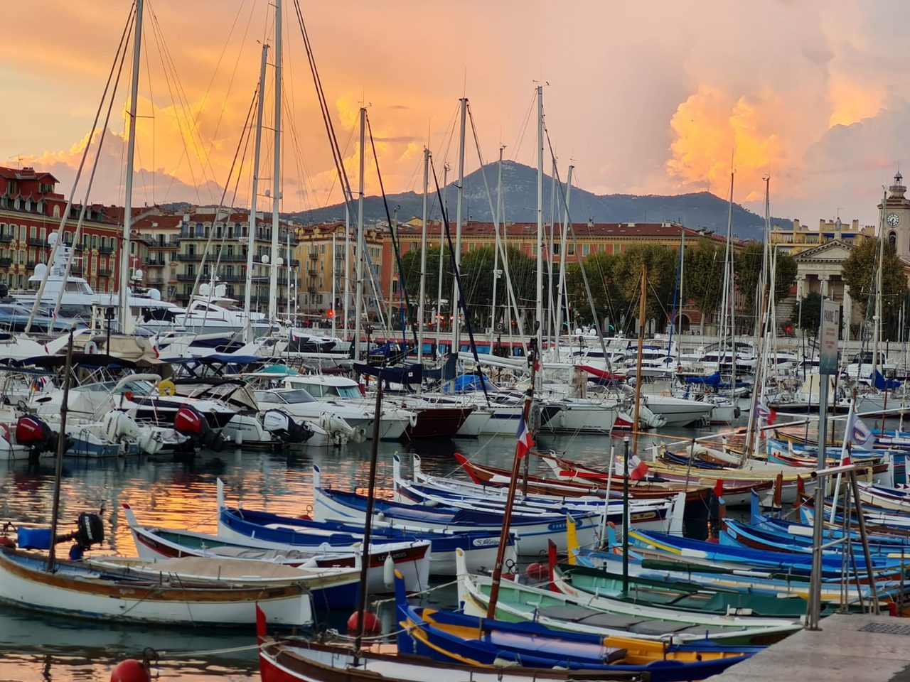 Hafen im Abendlicht, Fischerboote und Segelmasten vor rosa leuchtenden Wolken