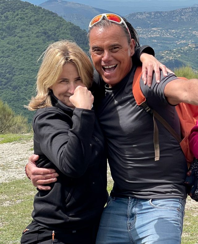 Charlotte auf einer Bergwanderung über der Côte d’Azur, Arm in Arm mit einem Mitwanderer