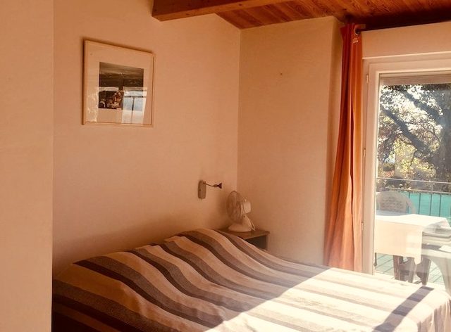 Zimmer mit Doppelbett, Holzdecke und Balkont&uuml;r ins Gr&uuml;ne