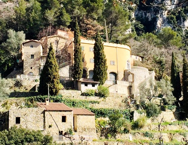 Le Castel Caramel &agrave; flanc de coteau&nbsp;: villa ocre au-dessus des terrasses de pierre, hauts cypr&egrave;s au premier plan