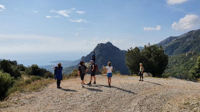 Wandergruppe auf einem Kamm bei Sainte-Agn&egrave;s, dahinter Berg und Dunst &uuml;ber dem Meer