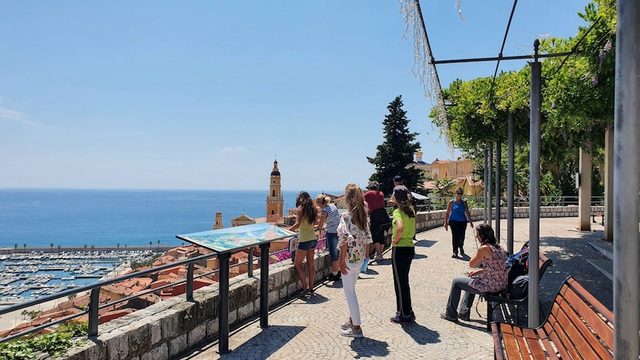 Gruppe an einem Aussichtspunkt &uuml;ber dem Hafen von Menton, unter einer Pergola